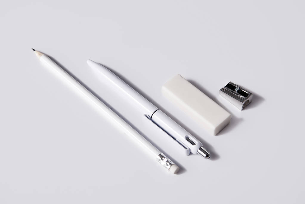 用铅笔、橡皮擦和削刀在白色表面上连续拍摄的笔, 用于样机