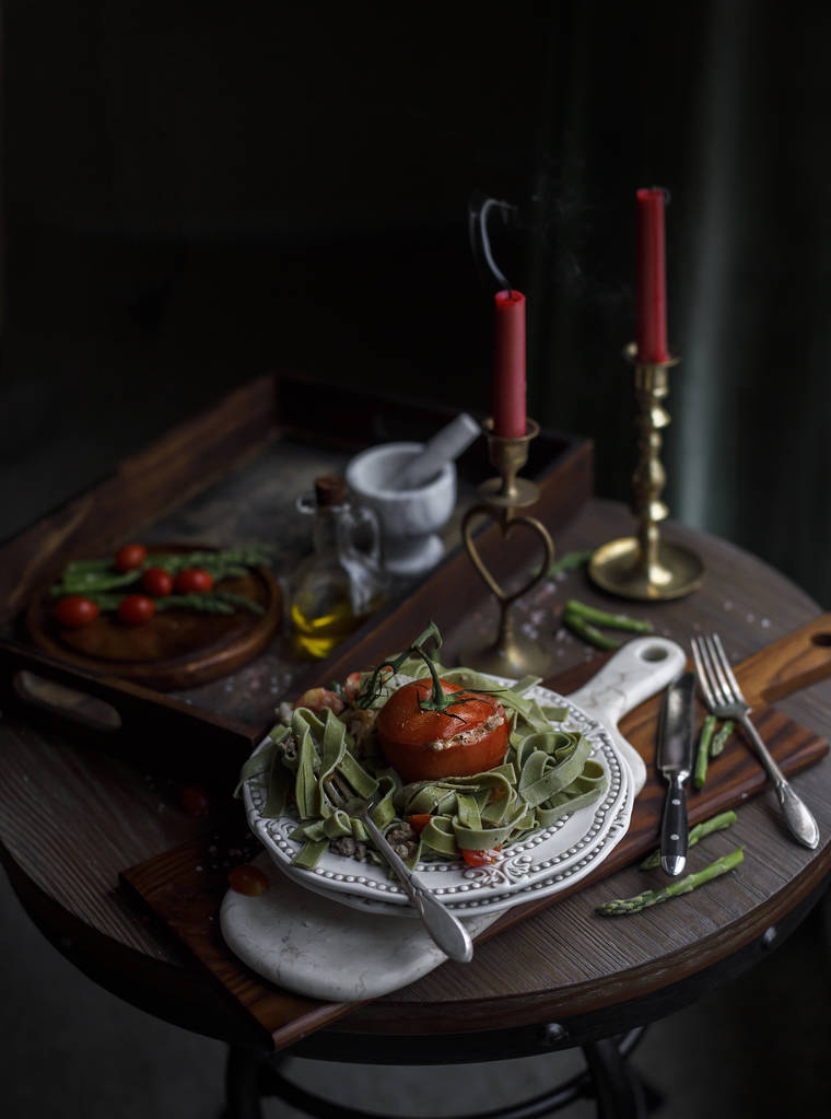 Spinach pasta with meat, tomatoes and cheese dark rustic background